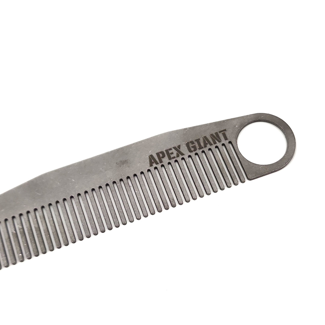 Titanium comb closeup showing fine teeth and engraved logo