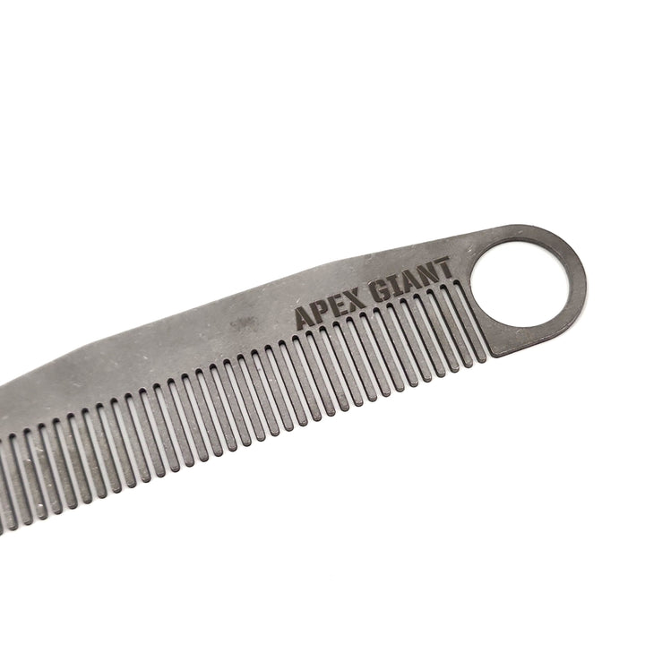 Titanium comb closeup showing fine teeth and engraved logo