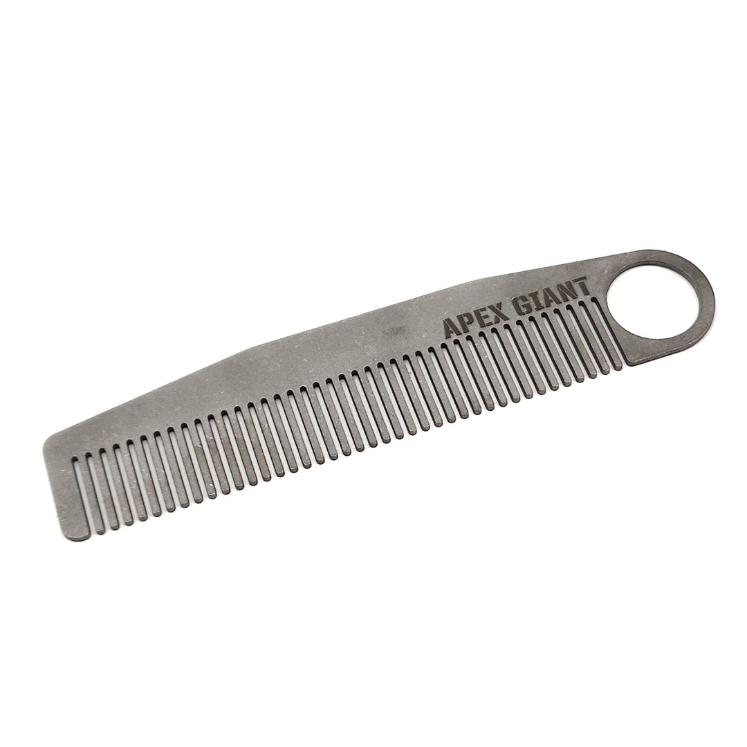 Titanium comb with ring end, fine teeth, and engraved text on handle
