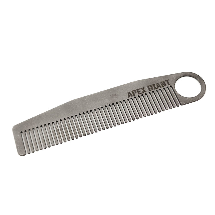 Titanium comb with ring end, fine teeth, and engraved text on handle