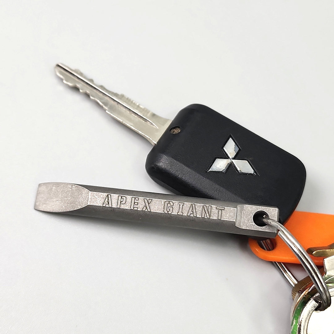 Keychain pry bar with black holder, Apex Giant pry tool, and orange keyring tag