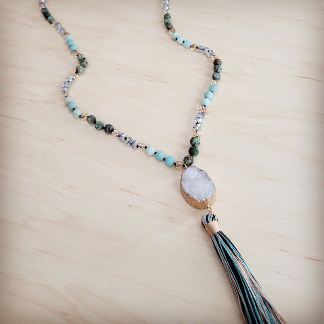 Long beaded necklace with light blue and dark accents and white druzy teardrop pendant