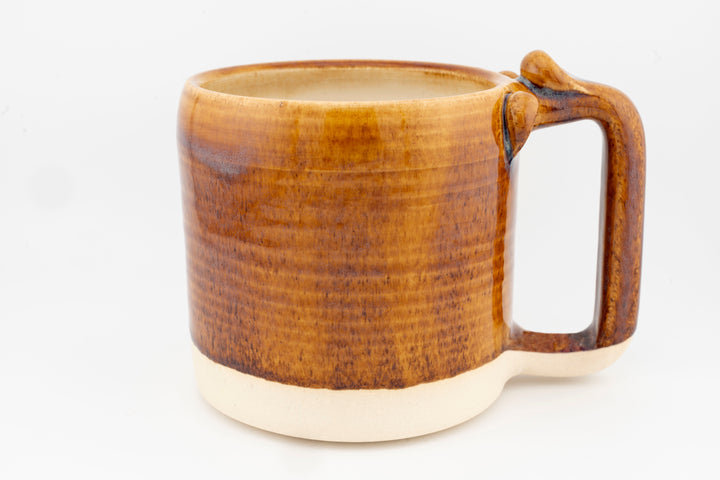 Ceramic mug with brown glaze, textured finish, and right-side handle.