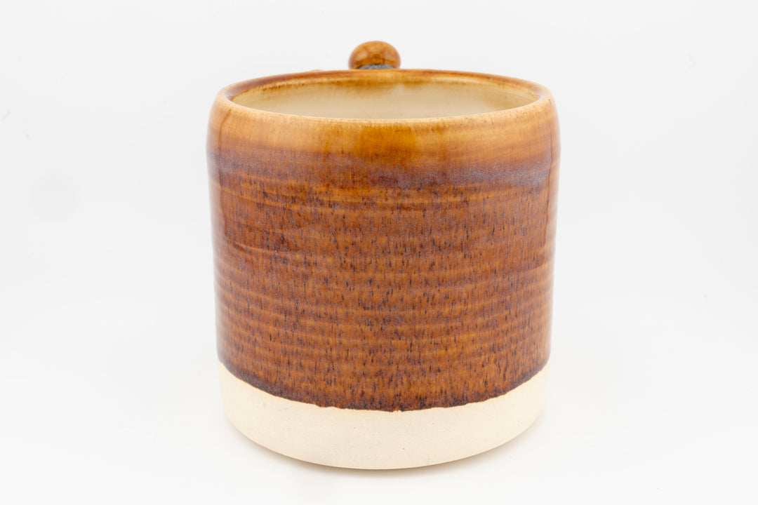Ceramic mug with brown textured glaze and rounded top opening.