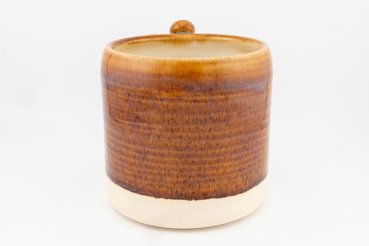 Ceramic mug with brown textured glaze and rounded top opening.