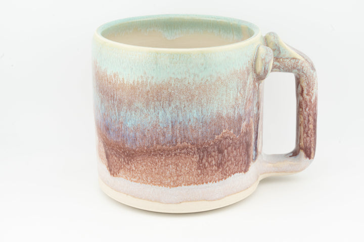 Ceramic mug with mint rim and peach-brown drip glaze, large side handle