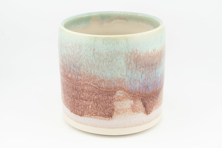 Ceramic mug with mint rim and peach-brown speckled drip glaze