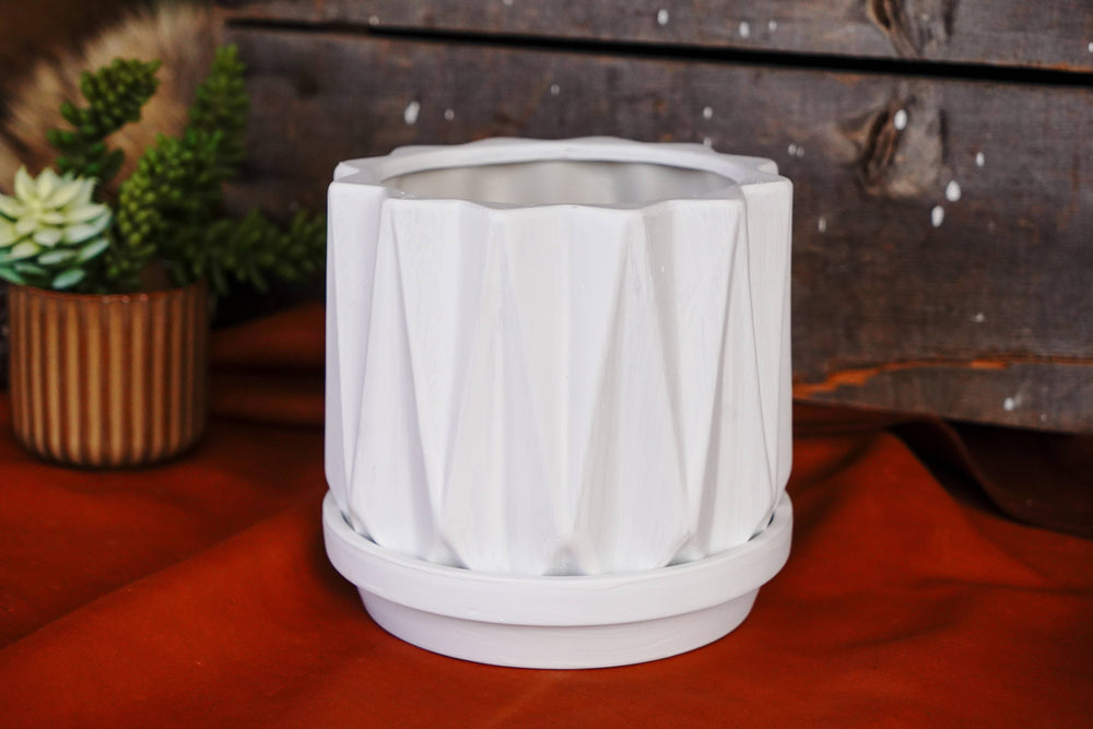 White geometric planter pot with angular ridges and flat base holder