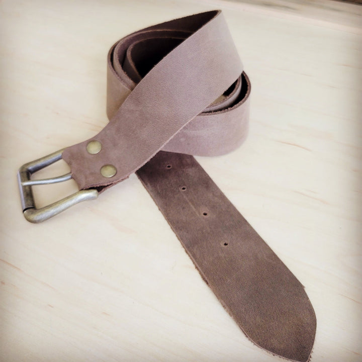 Distressed brown leather belt with silver buckle and eyelet holes, angled view