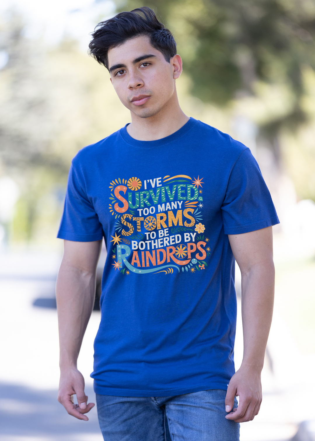 Unisex blue graphic t-shirt with colorful “Survived” storm-themed text