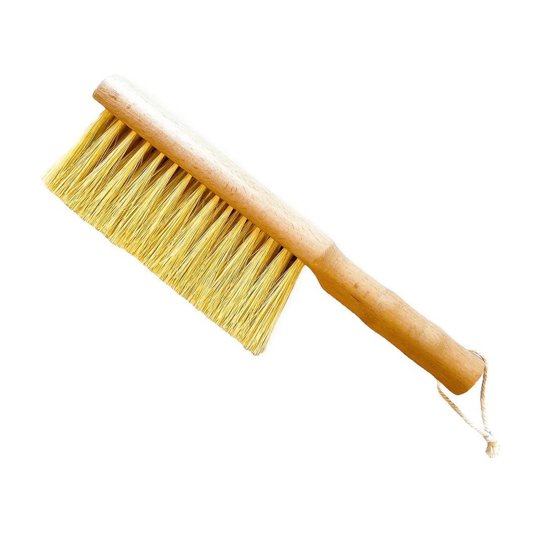 Garden brush with wooden handle and yellow bristle head, twine loop at end