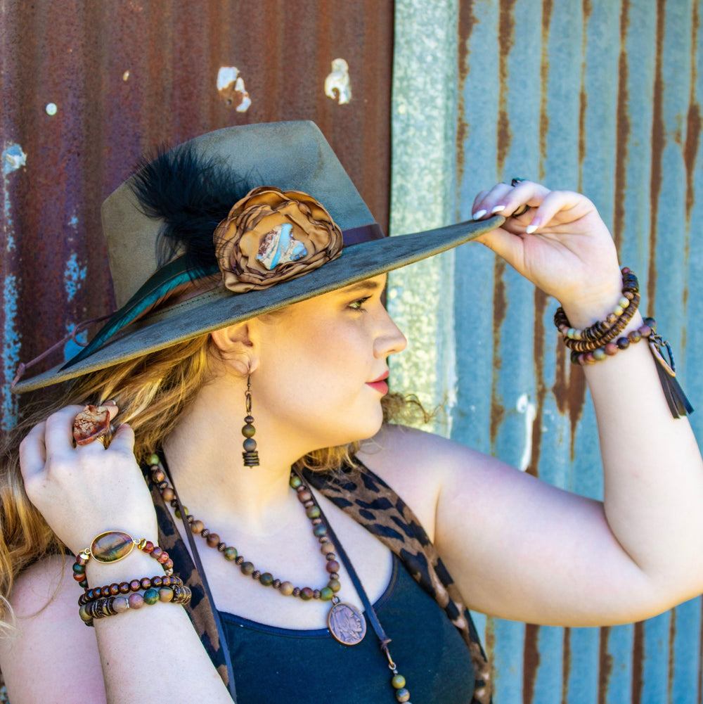 Wearing copper hoop drop earrings with purple jasper beads and dark wood accents