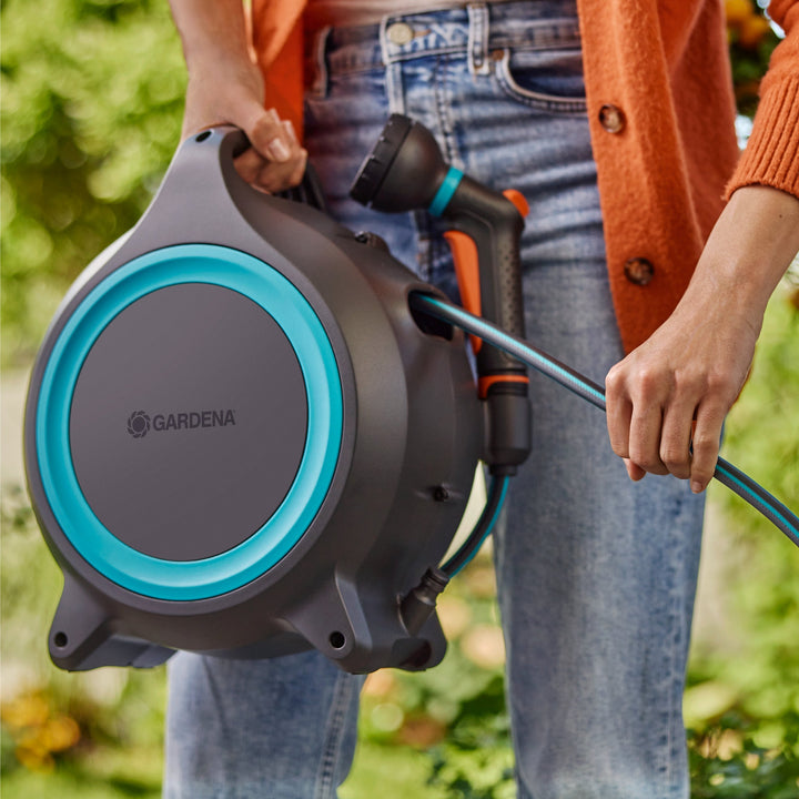 Portable hose reel with black-and-blue hose ring connected to a spray gun
