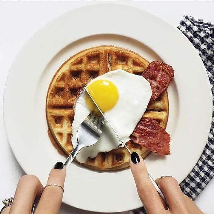 White 10 inch dinner plate with breakfast food and utensils on top
