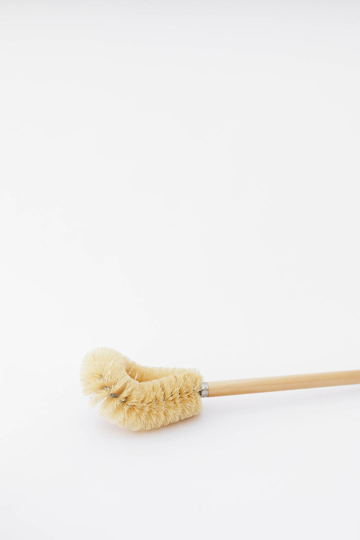 Round beige bristle head on light wood toilet brush handle
