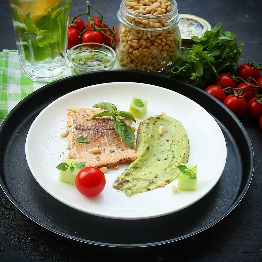 White round dinner plate with smooth rim, filled with food.