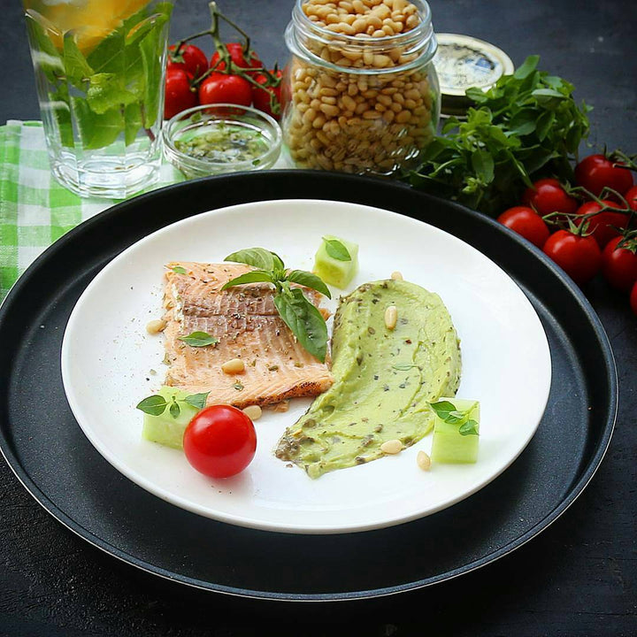 White round dinner plate with smooth rim, filled with food.