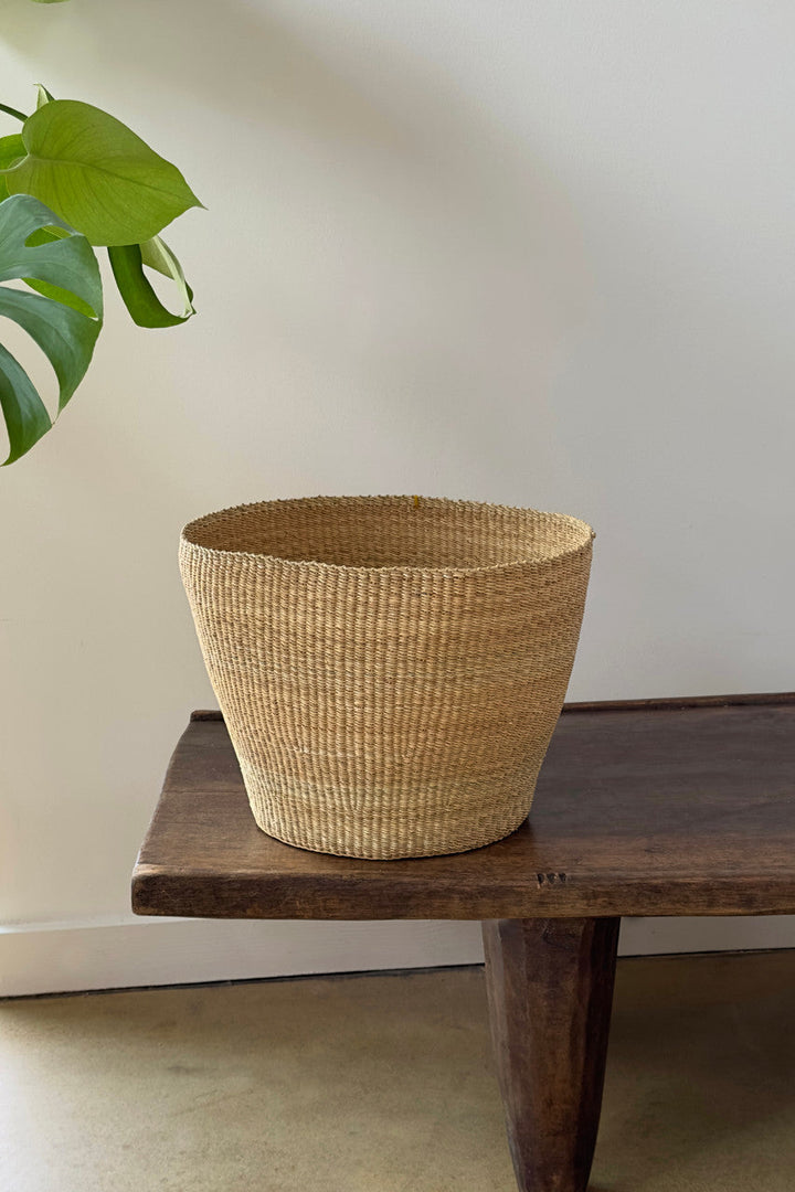 Natural woven planter basket with rounded rim and tapered sides