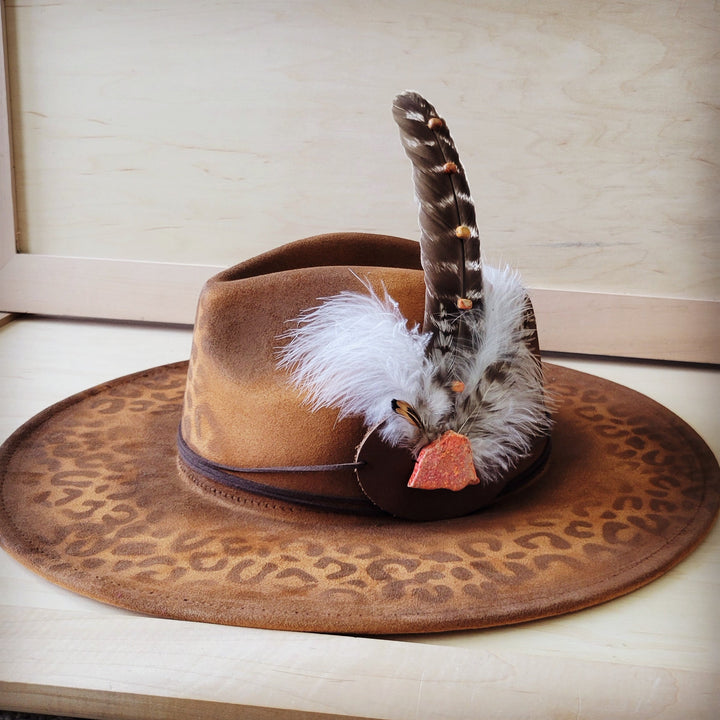 Tan felt leopard cowgirl hat with side feather detail and brown rope tie trim