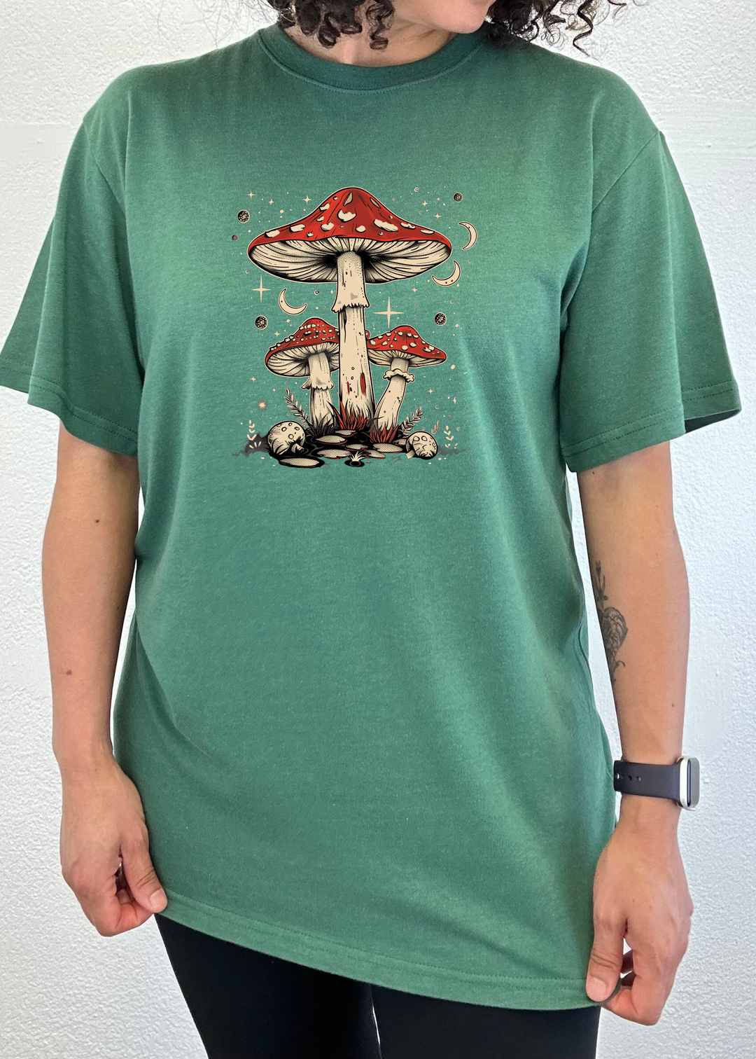 Teal green unisex T-shirt with red-capped mushroom graphic centered on chest