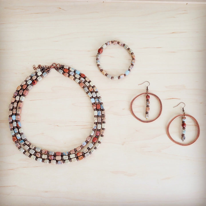 Copper hoop earrings with stacked bead fringe in red, white, and metallic tones