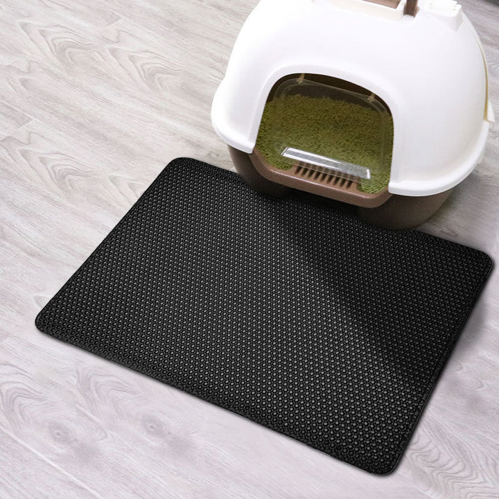 Black EVA pet cat litter pad mat with honeycomb texture under a litter box