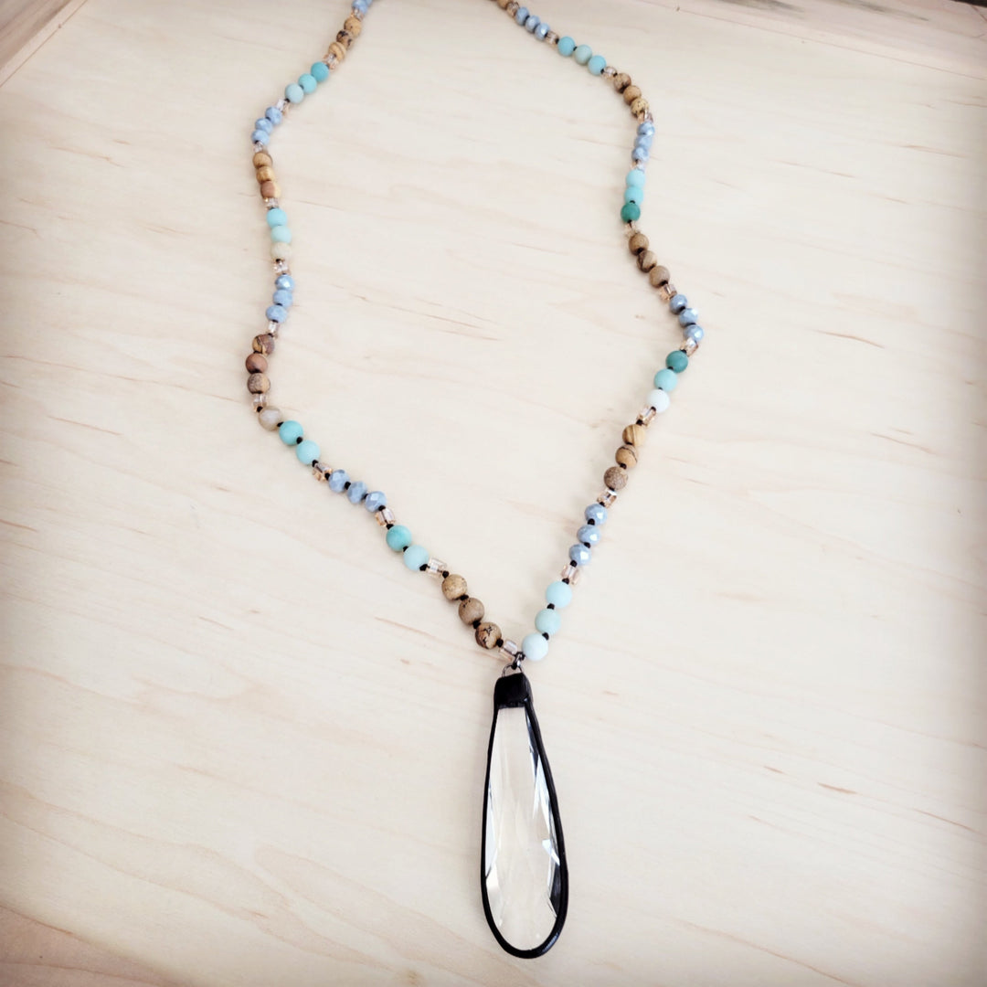 Long beaded necklace with blue and tan bead strand and teardrop crystal pendant