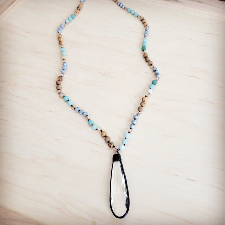 Long beaded necklace with blue and tan bead strand and teardrop crystal pendant
