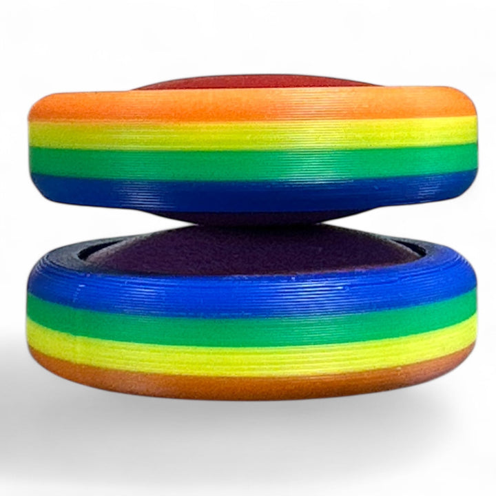 Rainbow pride ring stack with orange, green, blue stripes and dark inner opening.