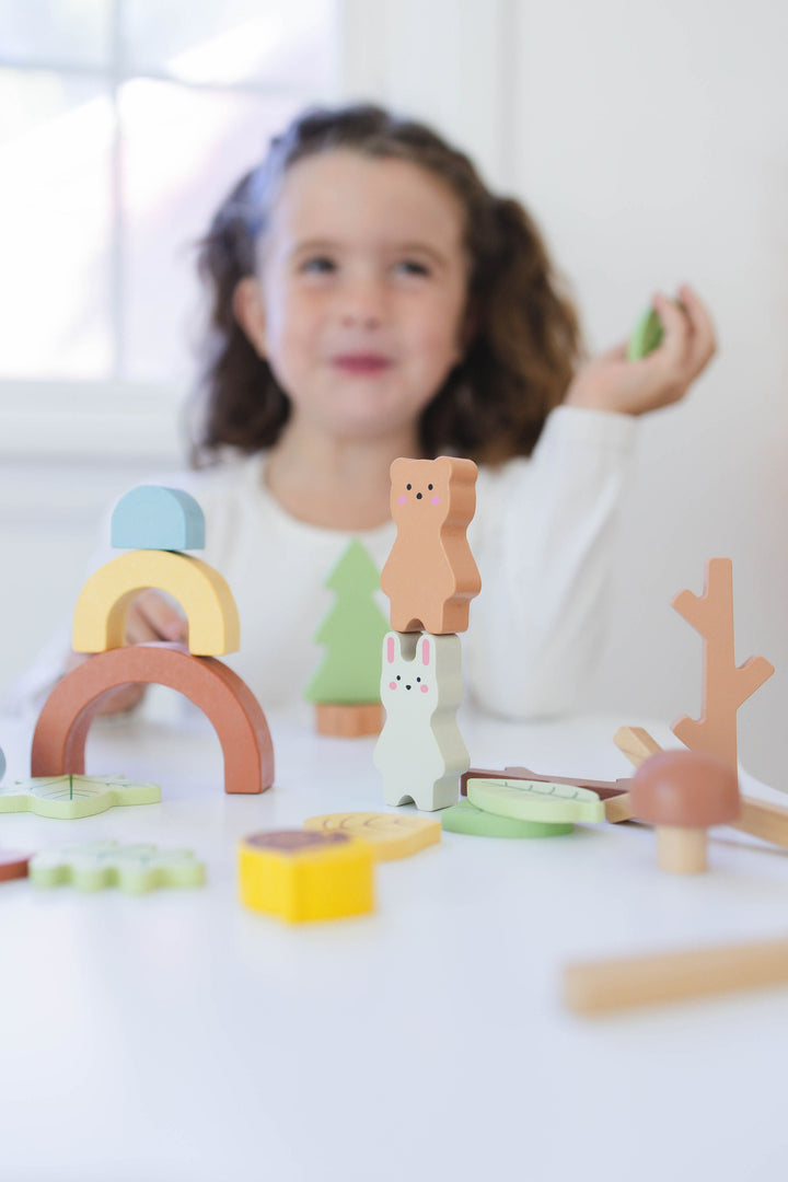 Wooden forest sensory bin with stacked wooden pieces for toddler play