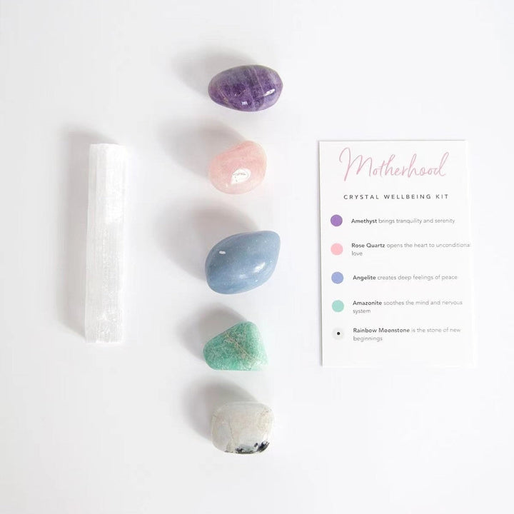 Crystal healing kit with white selenite wand, purple and blue stones, plus instructions card.