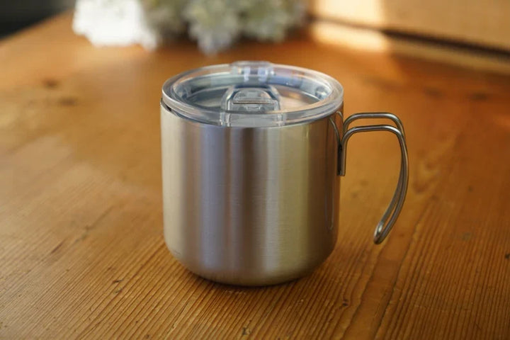 Double-walled stainless steel mug with transparent lid and loop handle, silver.