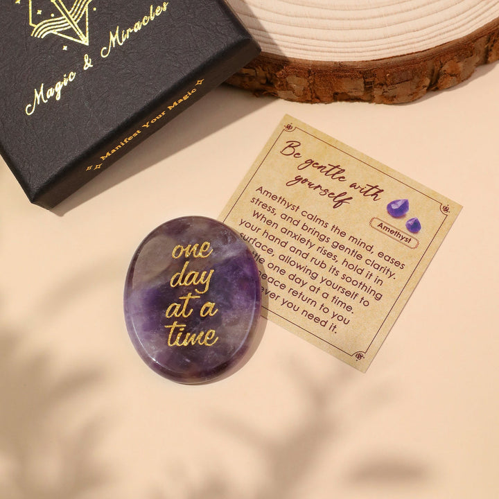 Purple oval pocket crystal stone with gold “one day at a time” text