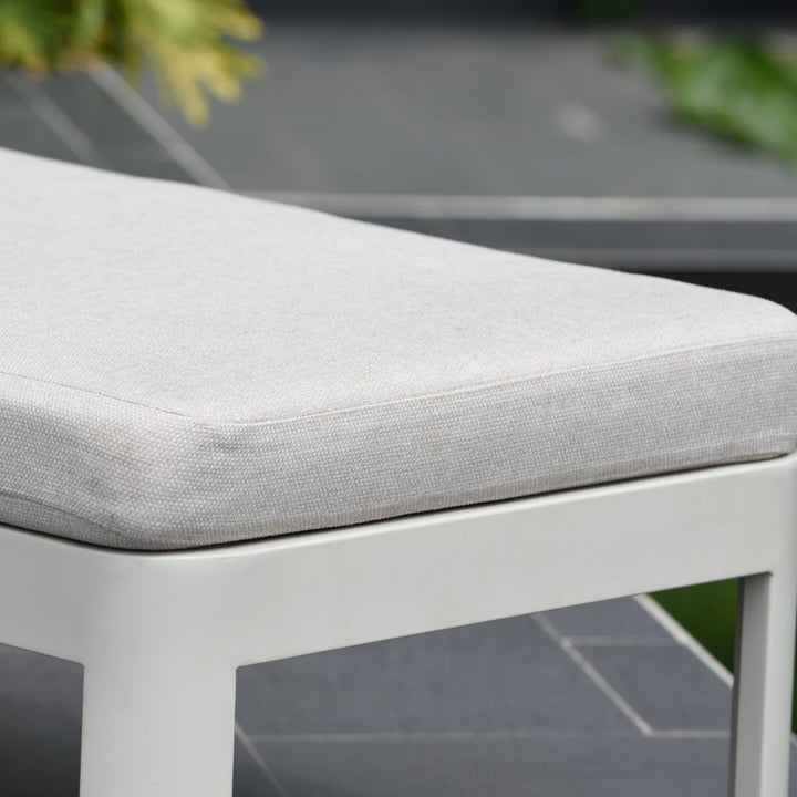 Light beige padded sun lounger seat cushion with smooth fabric and stitched edges