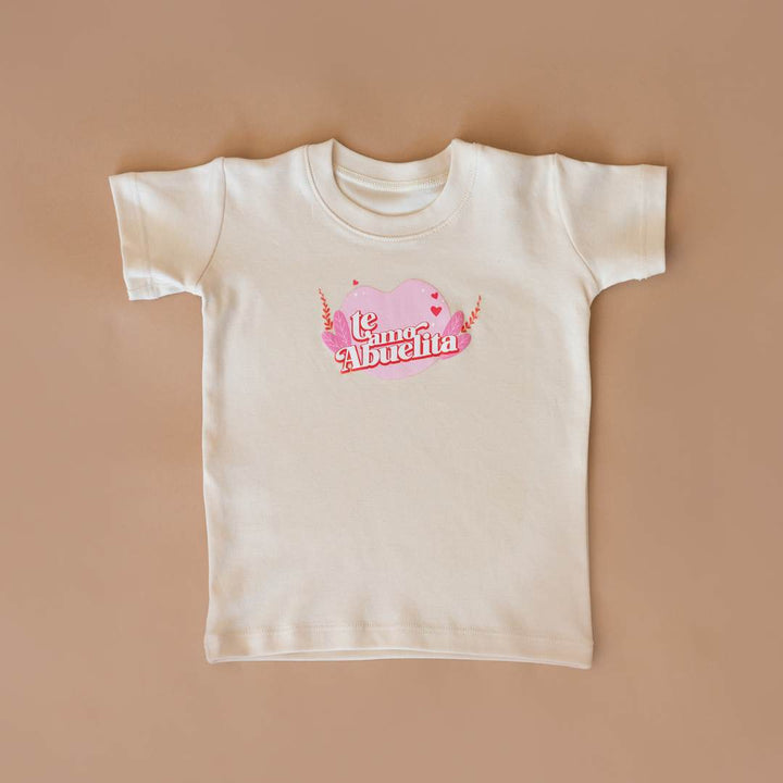 Cream organic cotton graphic tee with pink heart "Te amo, Abuelita" design