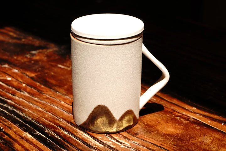 Ceramic tea mug with lid and side handle, built-in strainer, beige with dark mountain base