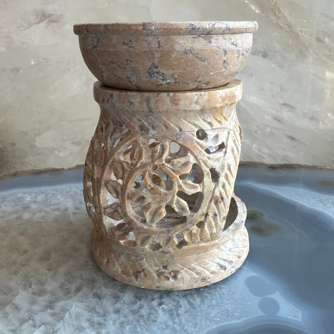 Carved soapstone essential oil burner with circular open center and floral relief