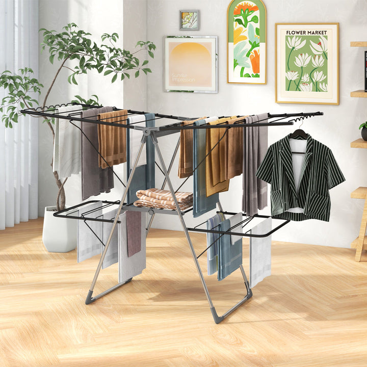 2-tier clothes drying rack with black rails and height-adjustable gullwing tiers, hanging clothes