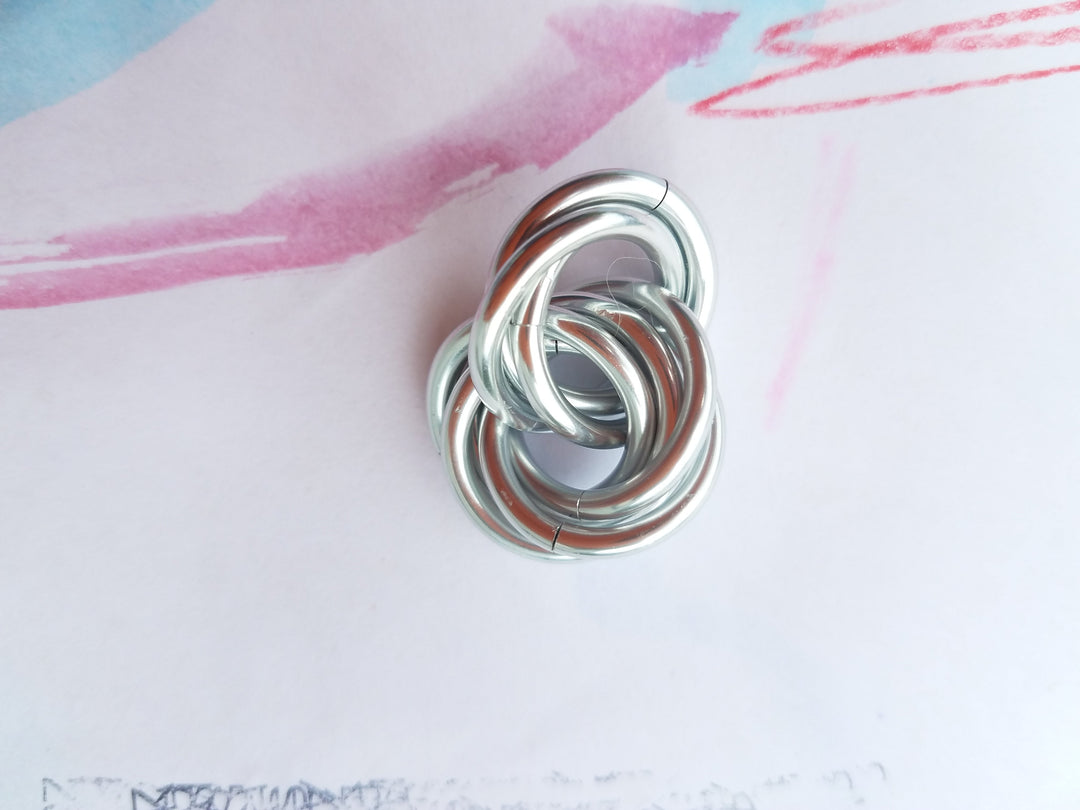 Silver metallic stress fidget ball with coiled loop design