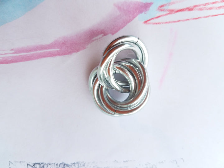Silver metallic stress fidget ball with coiled loop design