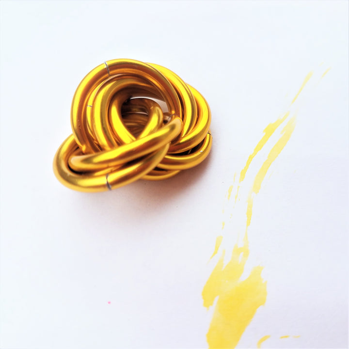 Metallic gold twisted stress ball fidget toy, coiled rings shape