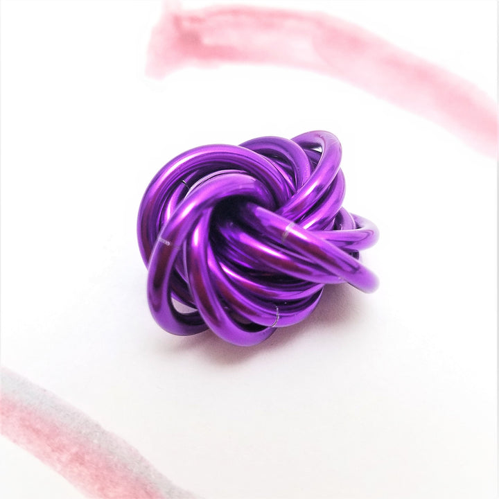 Purple and pink metallic twist fidget stress ball, knotted loop desk toy.