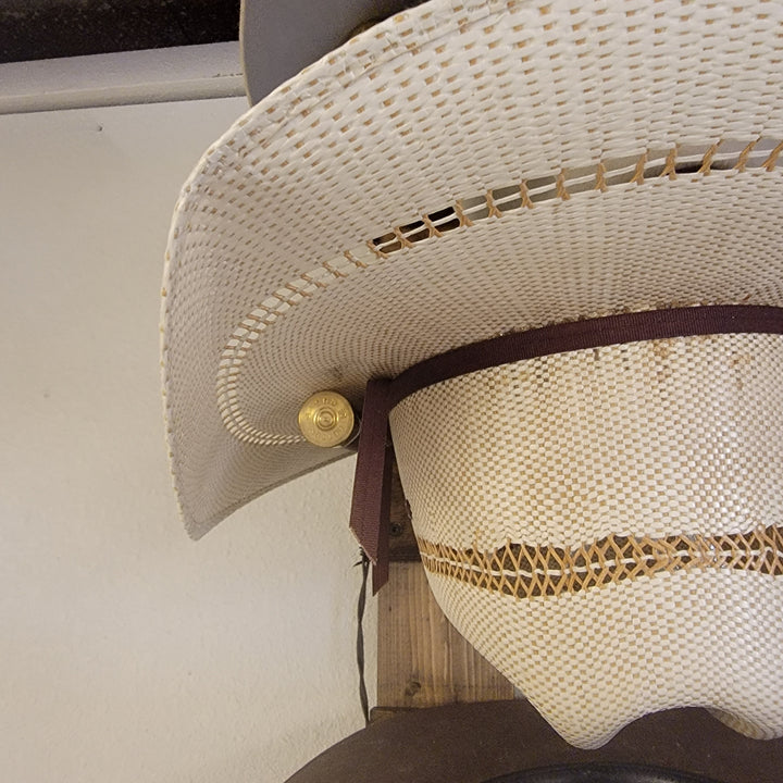 Close-up of cream straw hat with stitched brim detail on wall-hanging organizer