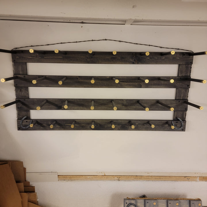 Horizontal peg-hook wall organizer with dark wood slats and multiple rows of gold pegs