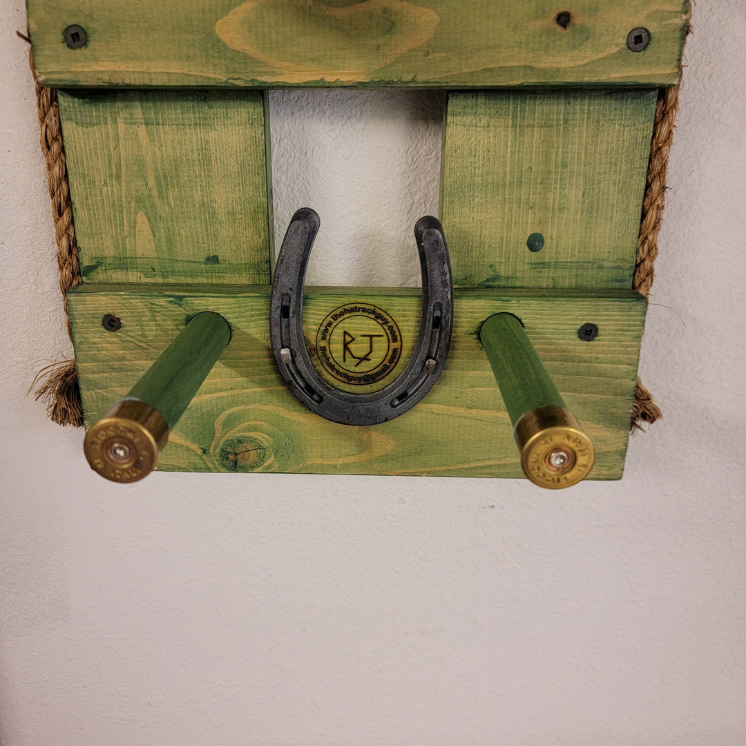Close-up of green wooden wall organizer with horseshoe motif and hooks