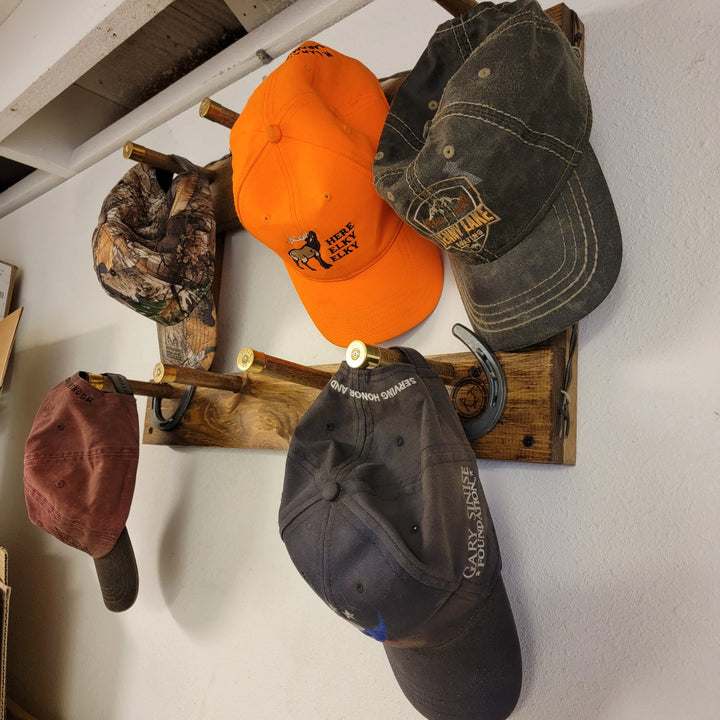Vertical wall-hanging ball cap organizer holding orange, dark denim, and camo caps
