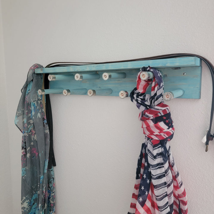 Blue scarf rack with shelf and rotating pegs, front view with scarves
