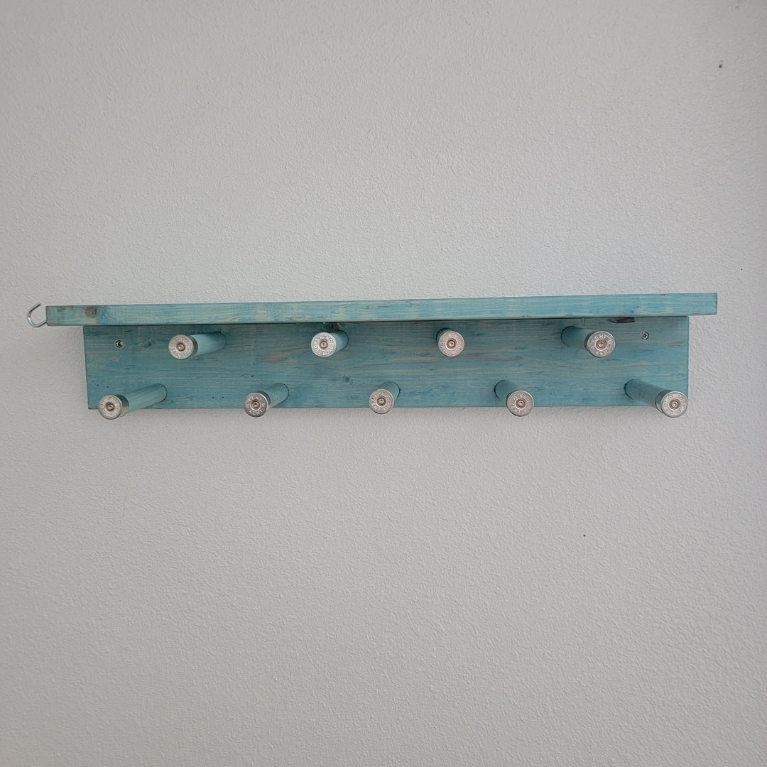 Blue wall-mounted scarf rack shelf with rotating pegs, no scarves