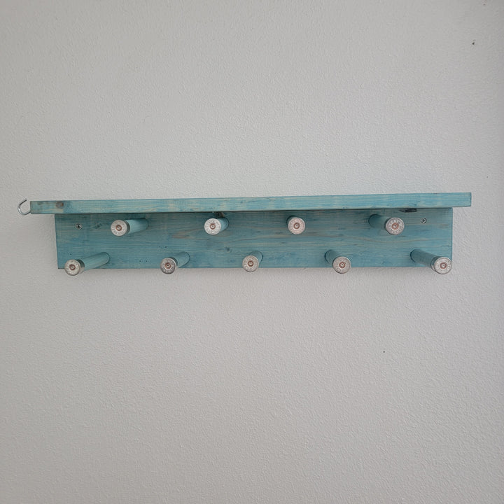 Blue wall-mounted scarf rack shelf with rotating pegs, no scarves