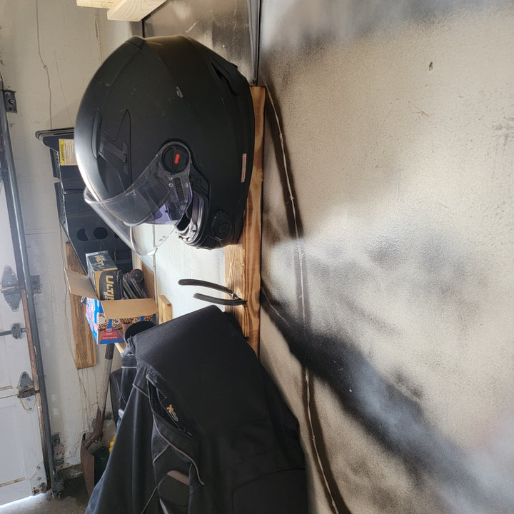 Wooden helmet rack with black motorcycle helmet and gear hooks